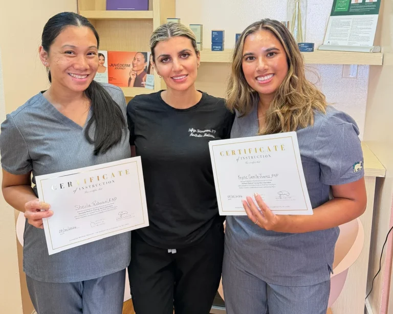 Two Contour training graduates holding their certificates of instruction beside their instructor