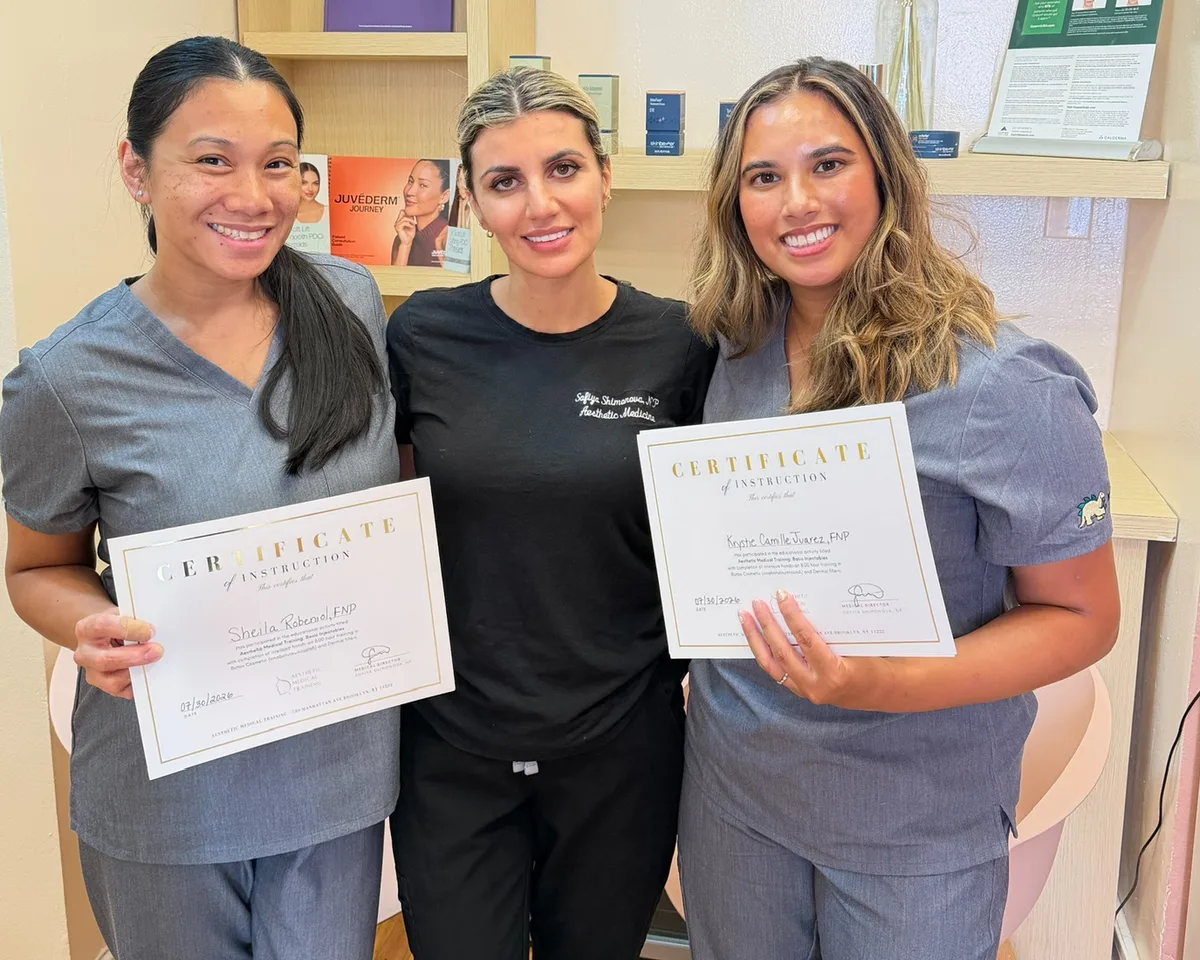 Two Contour training graduates holding their certificates of instruction beside their instructor
